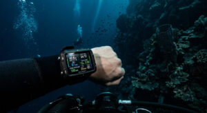 Close-up of a modern tech diver wrist computer deep underwater in the blue ocean.