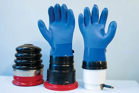 Las pruebas ayudan a asegurarse de que los sistemas de guantes funcionen correctamente. Algunos ejemplos de equipos de prueba de guantes (de izquierda a derecha): el inflador de guantes «Honeywell Salisbury G99», el adaptador de guantes «G100A», modificado para probar guantes secos, y el dispositivo de prueba de guantes hecho a mano, compuesto por un conector de reparación y una tapa con vástago de válvula. © Rich Selbiger
