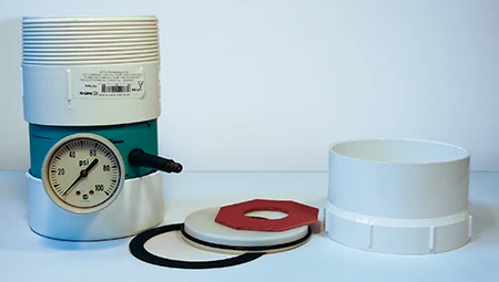 La cámara de presión de la válvula de escape viene con una junta, una tapa de prueba desmontable de 4 pulgadas (10 cm), una junta tórica, una placa de fijación y un adaptador hembra. © Rich Selbiger