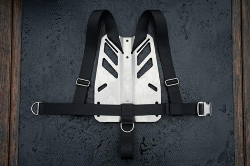Metal scuba backplate resting on a dive boat bench